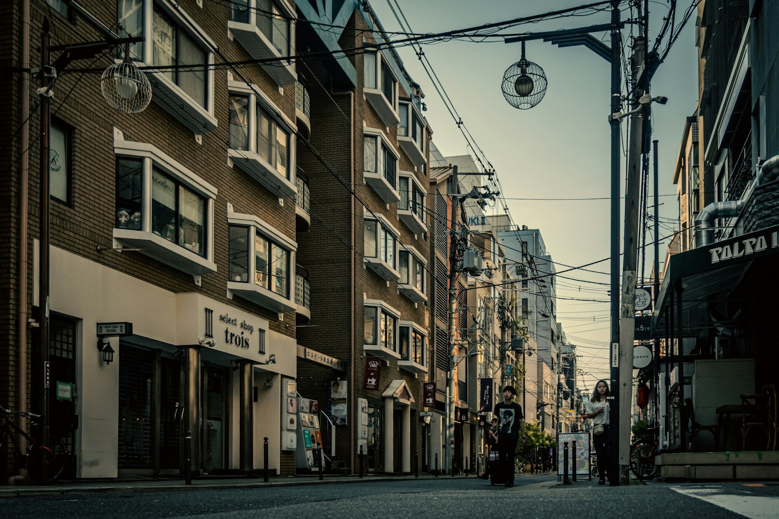 Ruhige Straßenszene mit einer stehenden Figur und alten Gebäuden entlang der Straße
