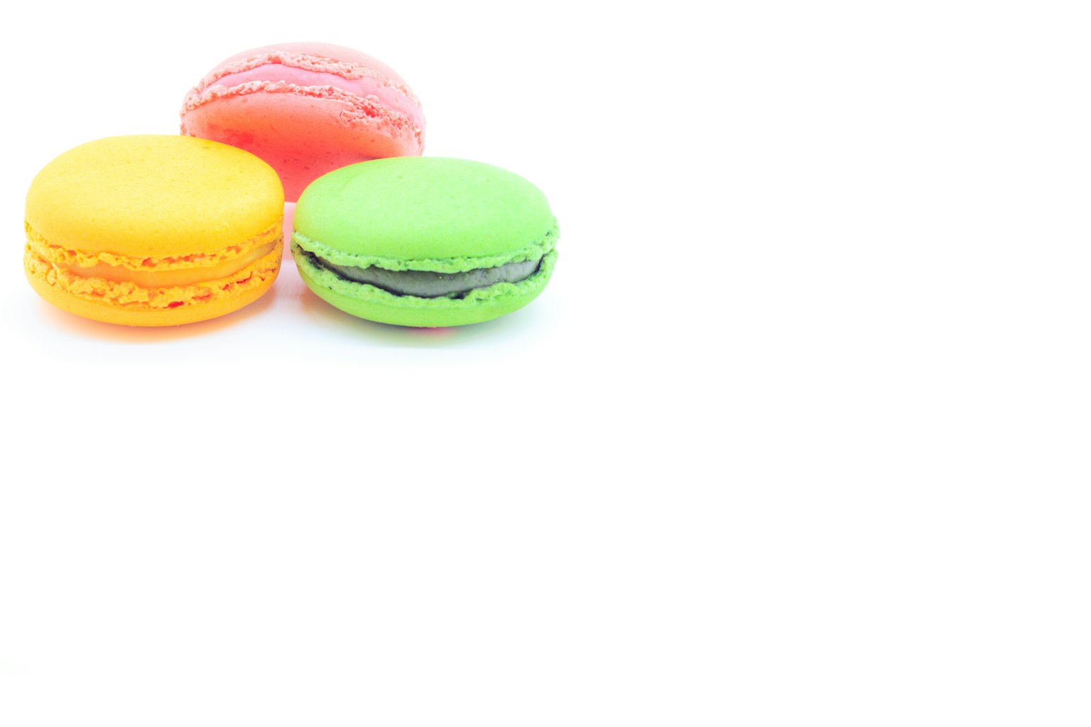 Colorful set of macarons in yellow, green, and pink shades