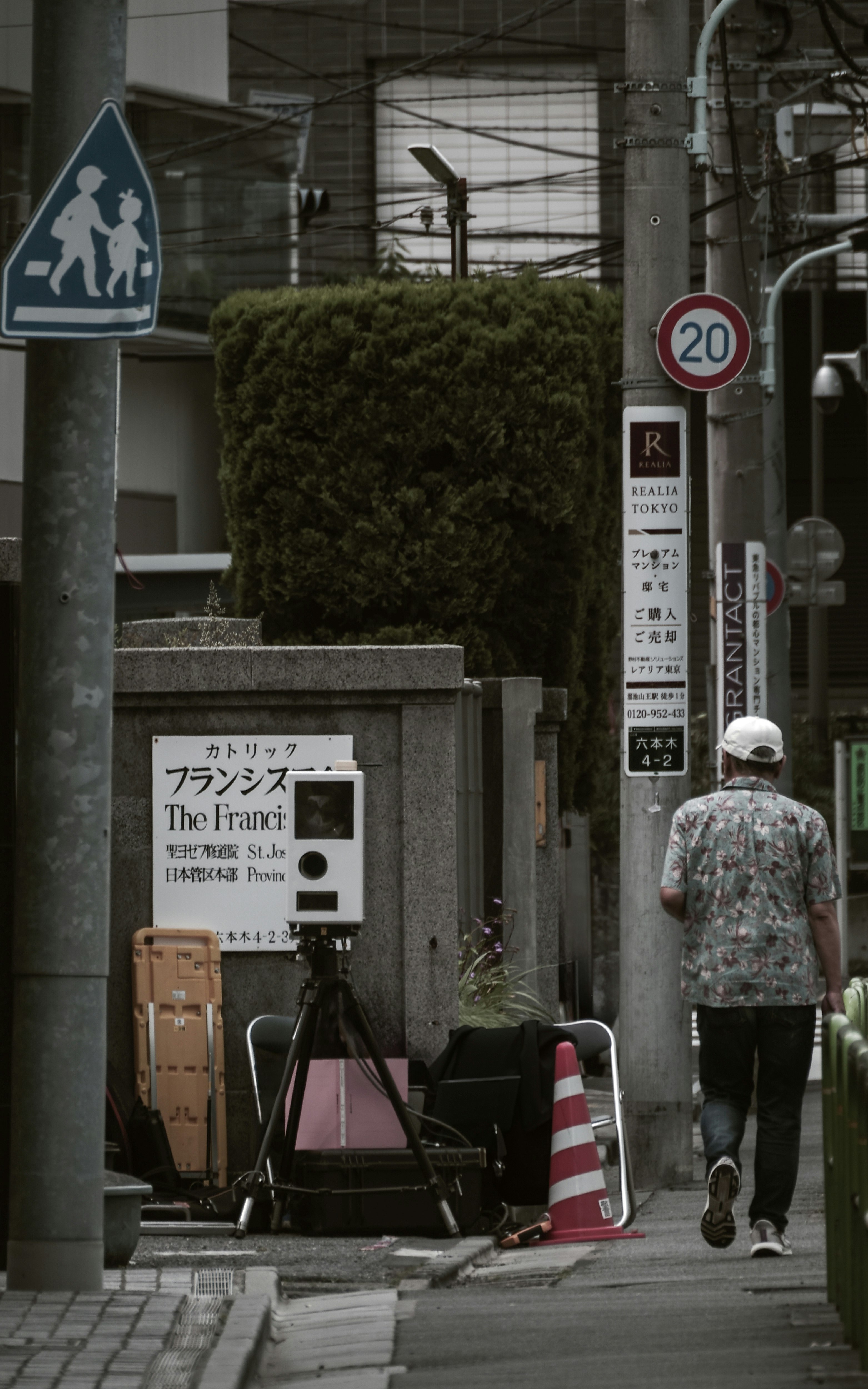 路地の歩道に設置された案内看板と撮影機材