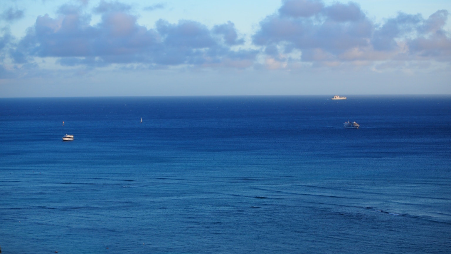 View of the blue ocean with several boats on the water
