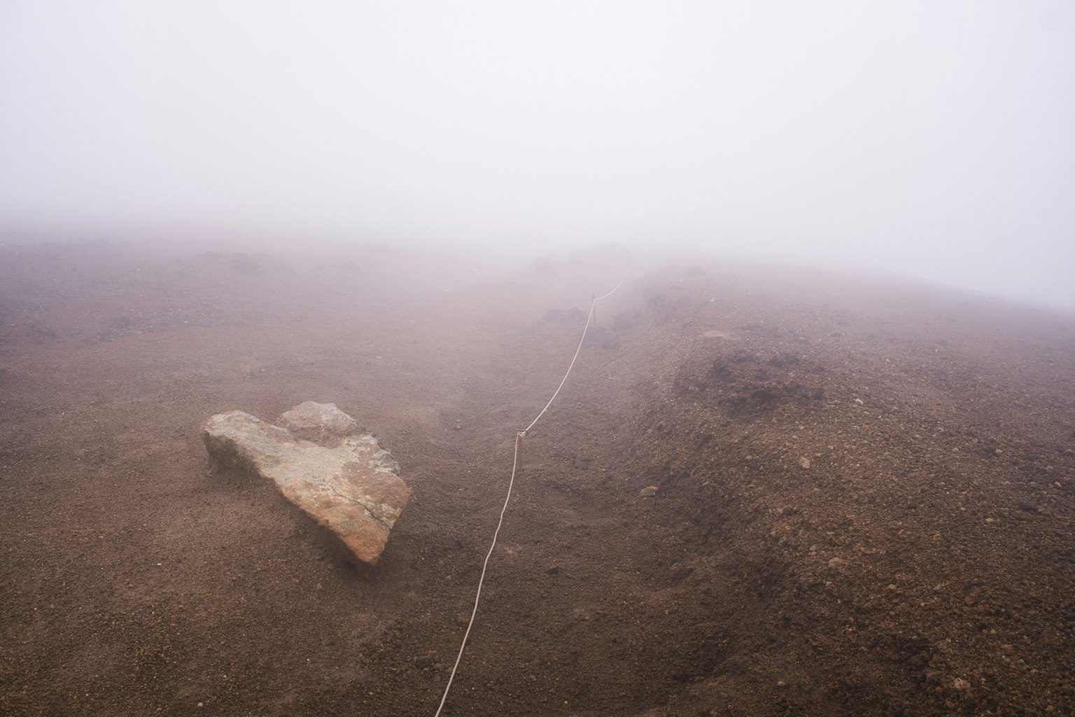Paesaggio con una roccia e una corda nella nebbia