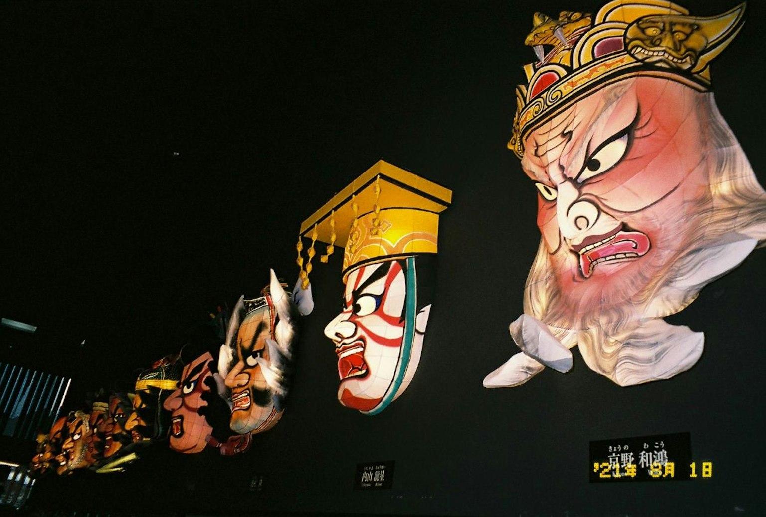 墙上展示的色彩丰富的传统日本面部雕塑