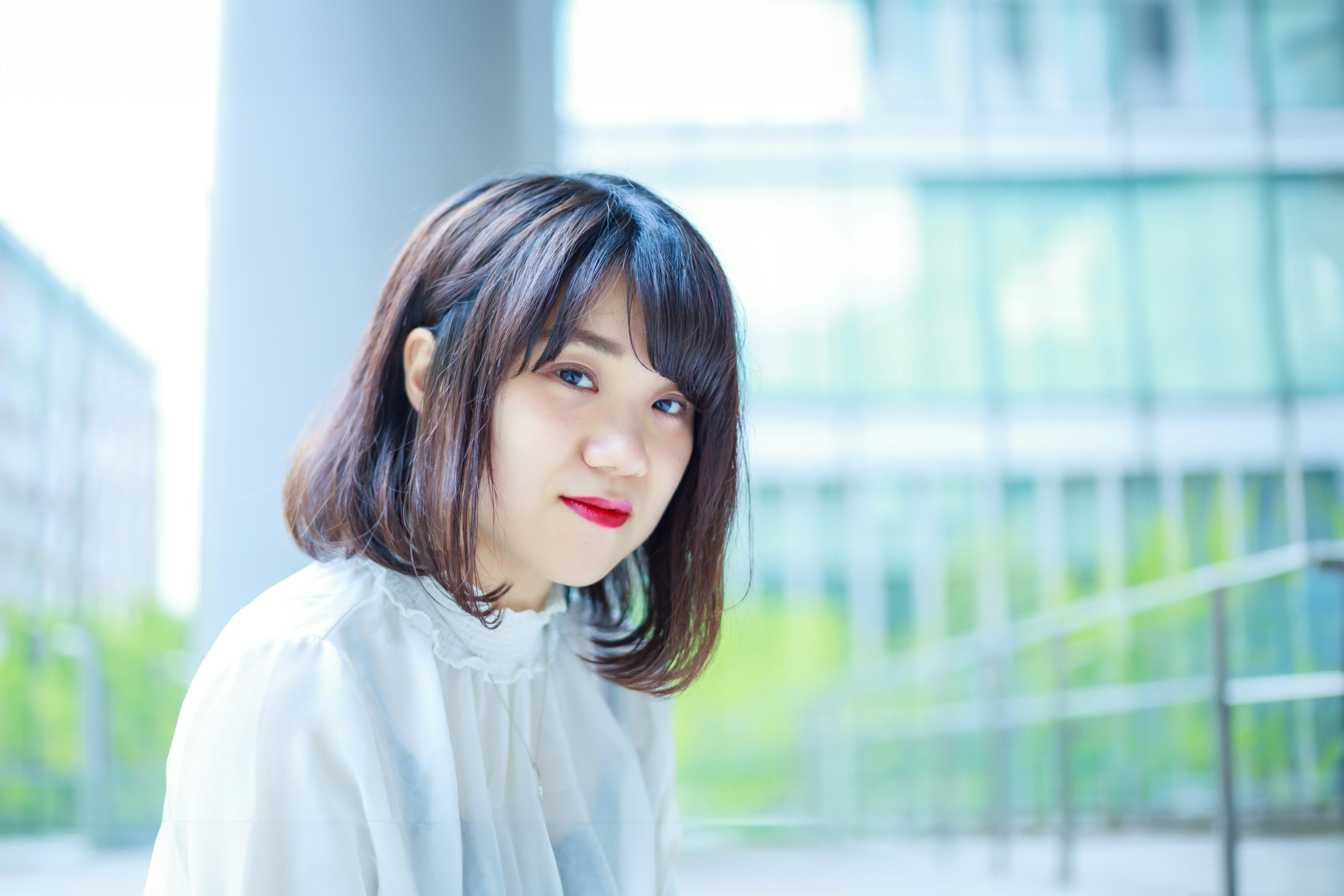 微笑的女性站在玻璃建築前