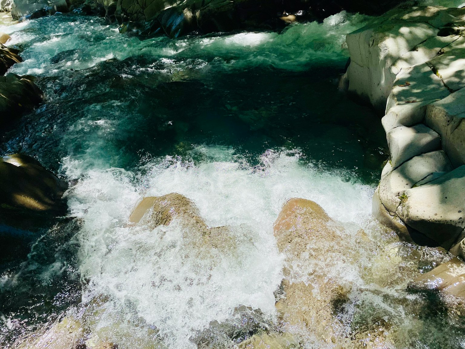 Fließender Fluss mit Wasserspritzern und Steinen