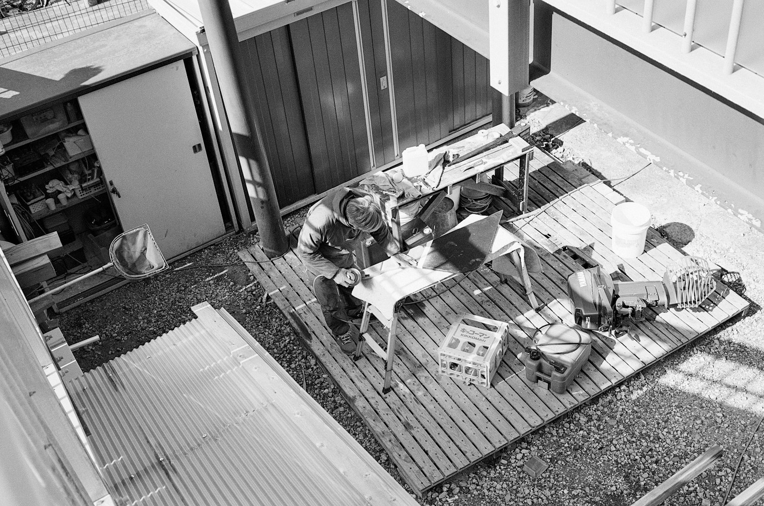 Spazio di lavoro all'aperto in bianco e nero con una persona al lavoro e strumenti visibili