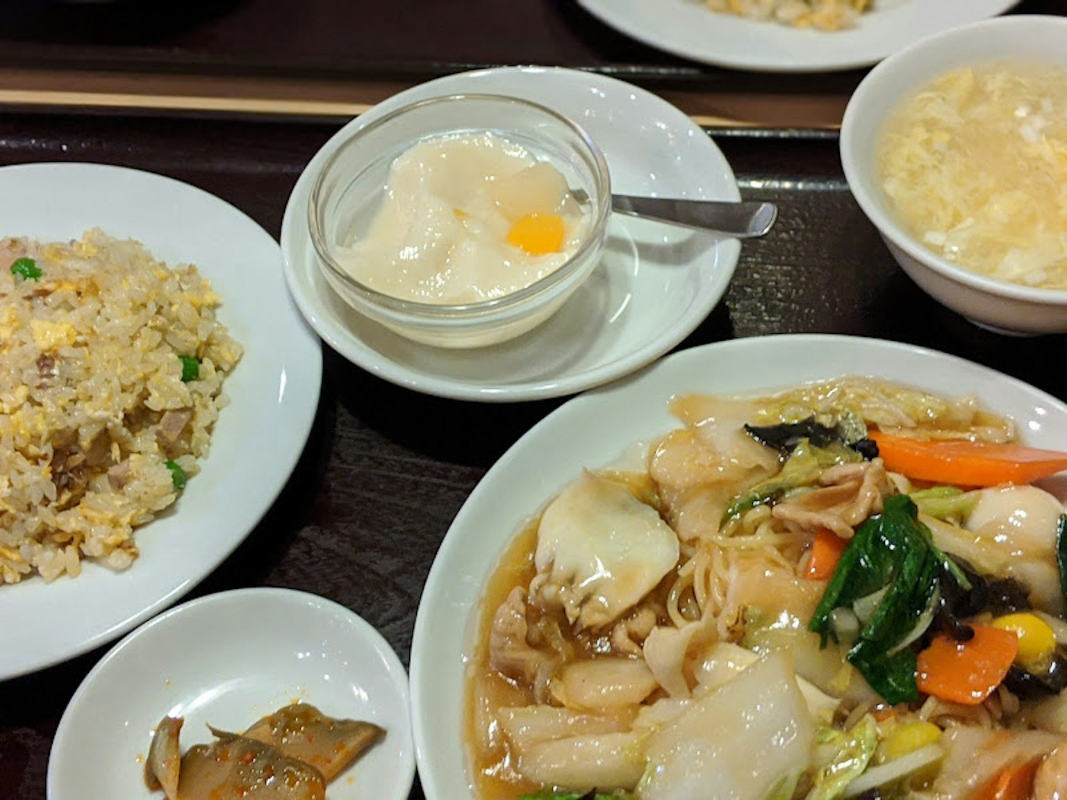 Piring masakan Cina berwarna-warni dengan nasi, sup, dan pencuci mulut