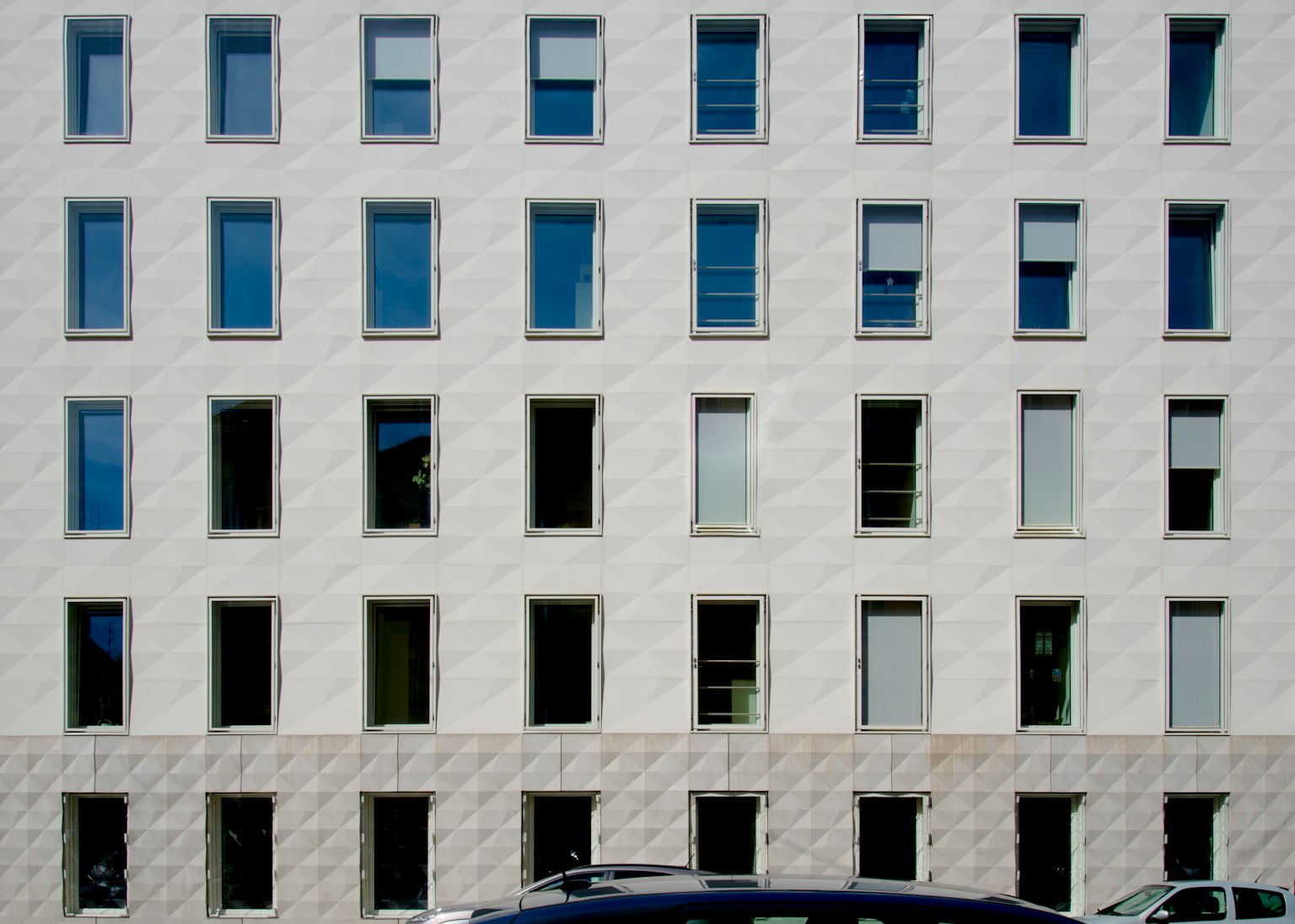 Modern building facade with neatly arranged windows on a white exterior