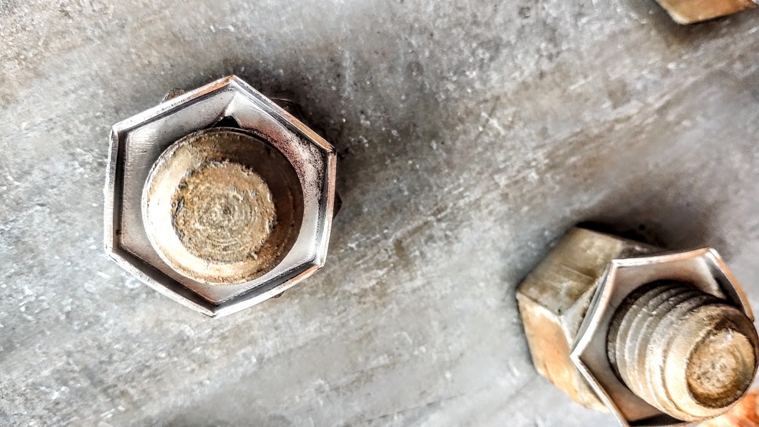 Primer plano de tuercas hexagonales sobre una superficie metálica