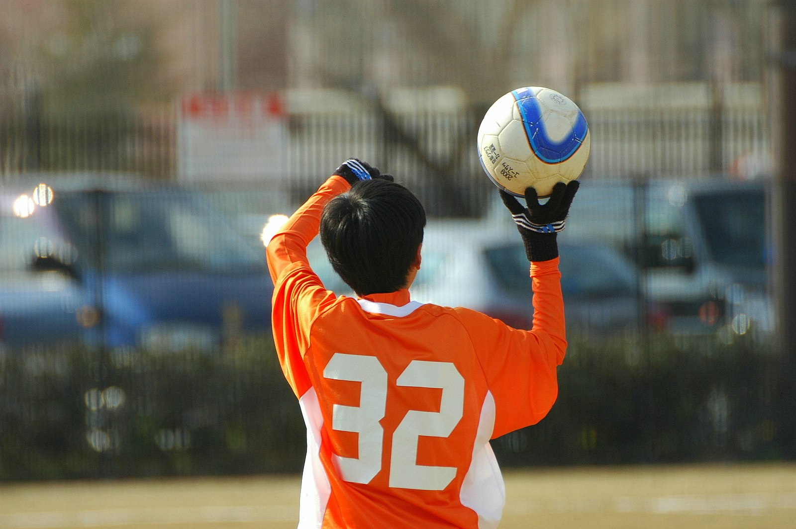 Ein Fußballspieler im orangefarbenen Trikot versucht, den Ball zu fangen