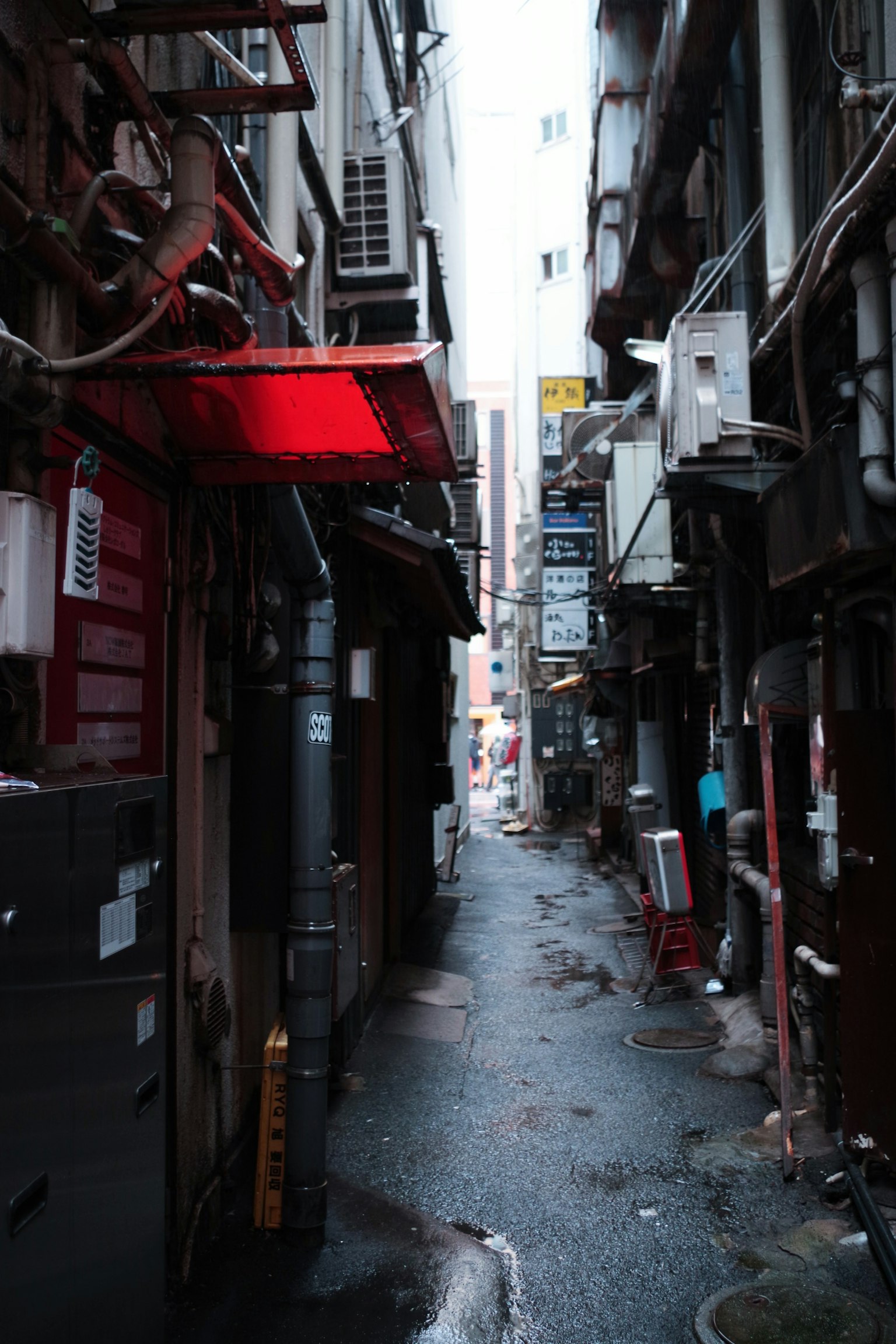 Narrow alleyway with red lighting in an urban setting