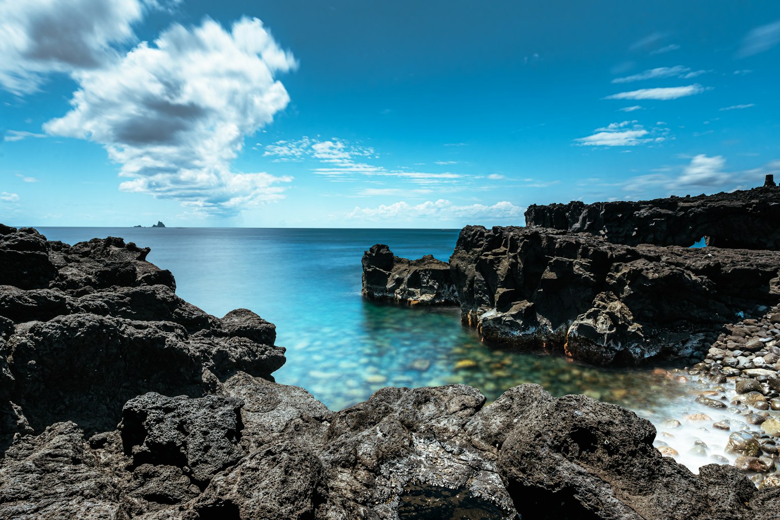 Pemandangan indah pantai berbatu dengan air biru jernih