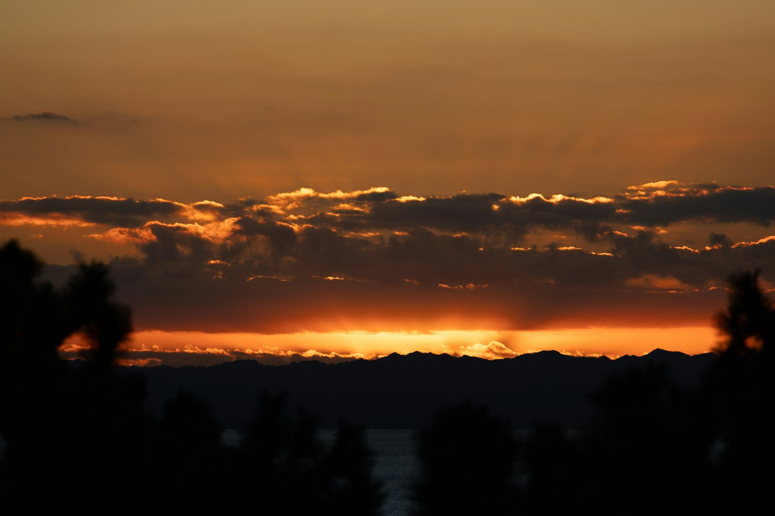 Bellissimo paesaggio al tramonto con silhouette di montagne e mare