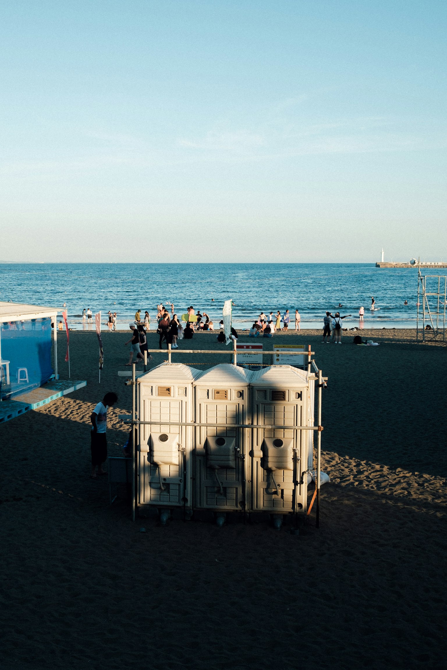 Baños portátiles en la playa con cielo azul