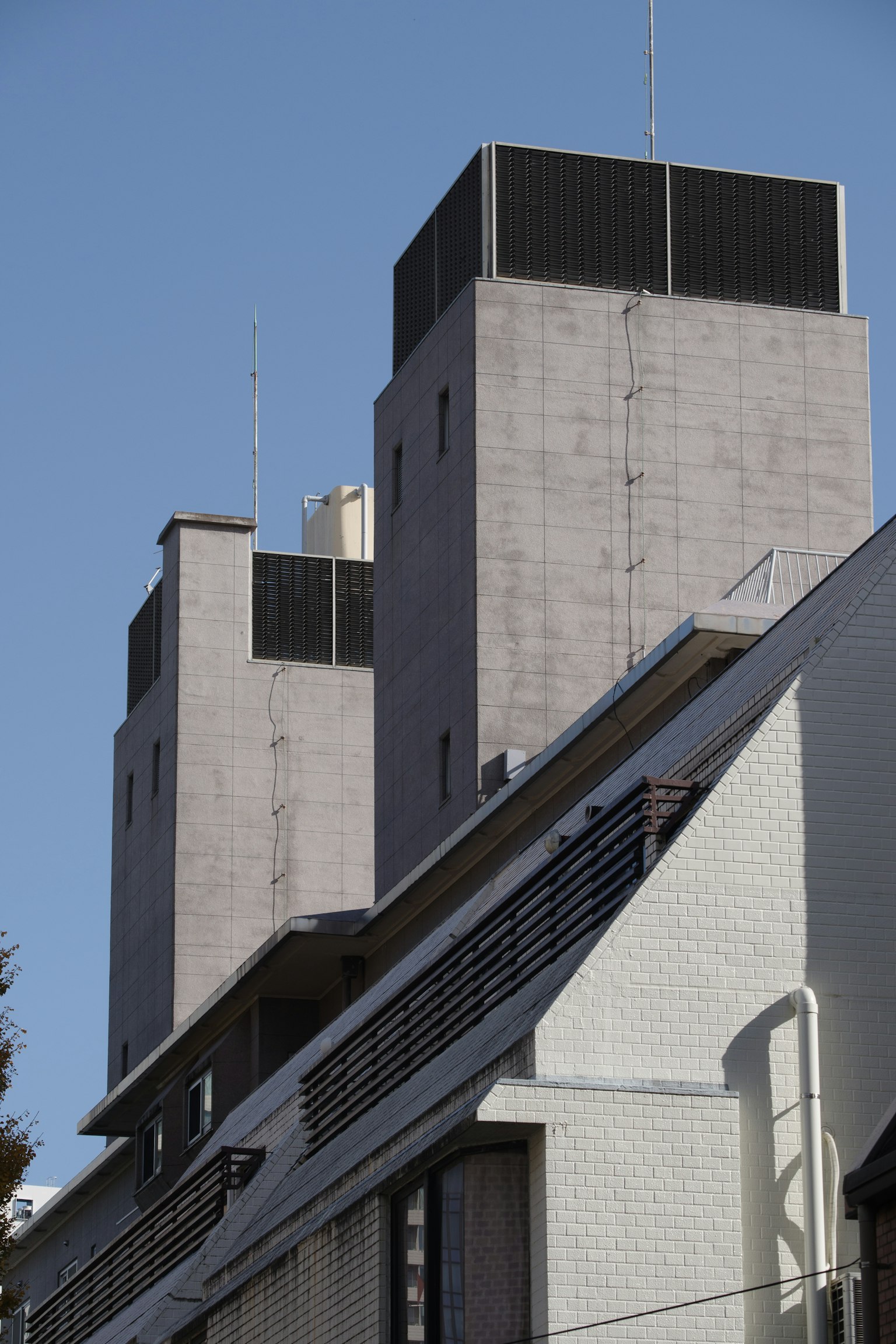 Concrete high-rise building towers under a clear blue sky