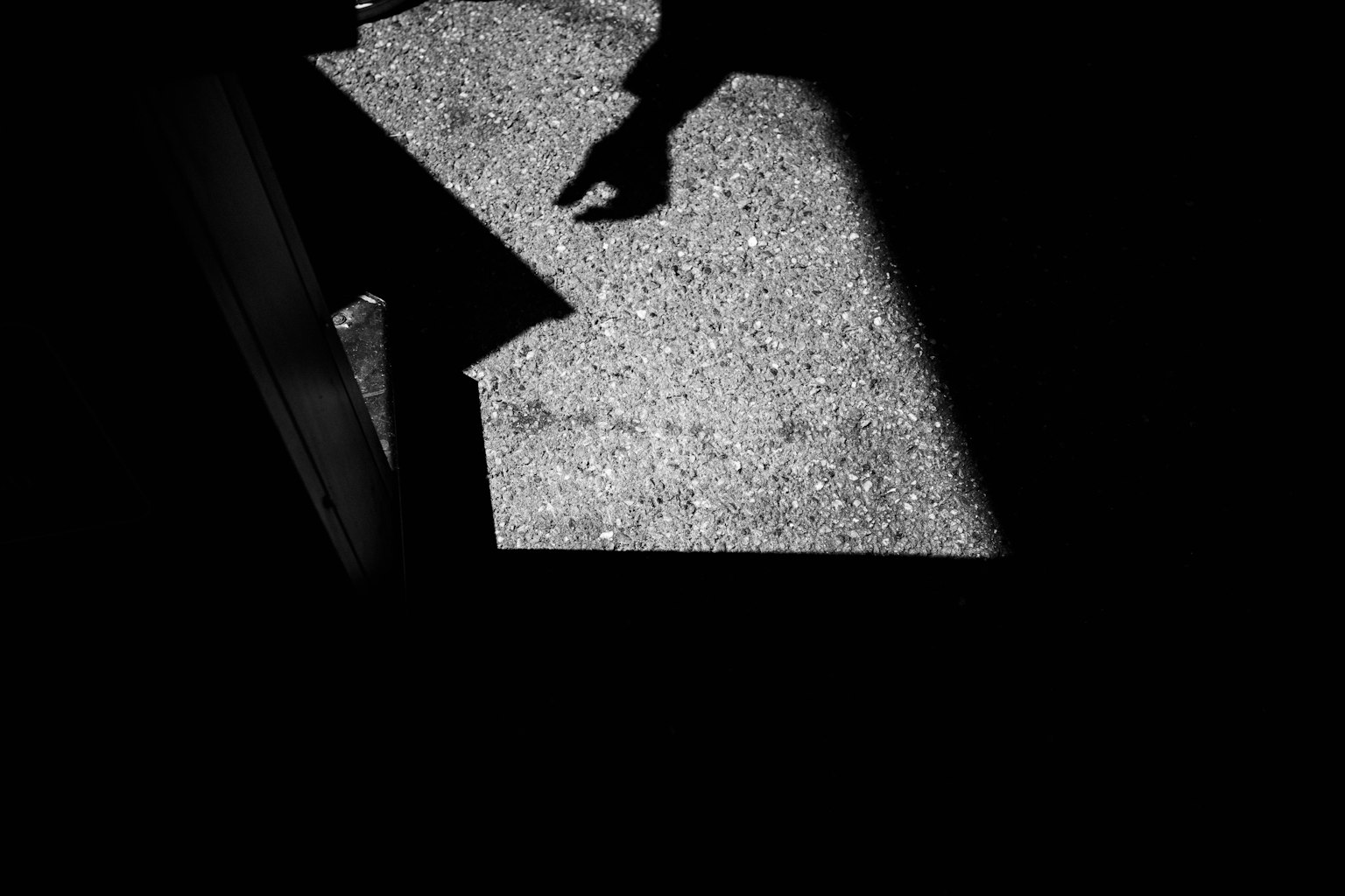 Una mano che si estende su un pavimento bianco con ombre
