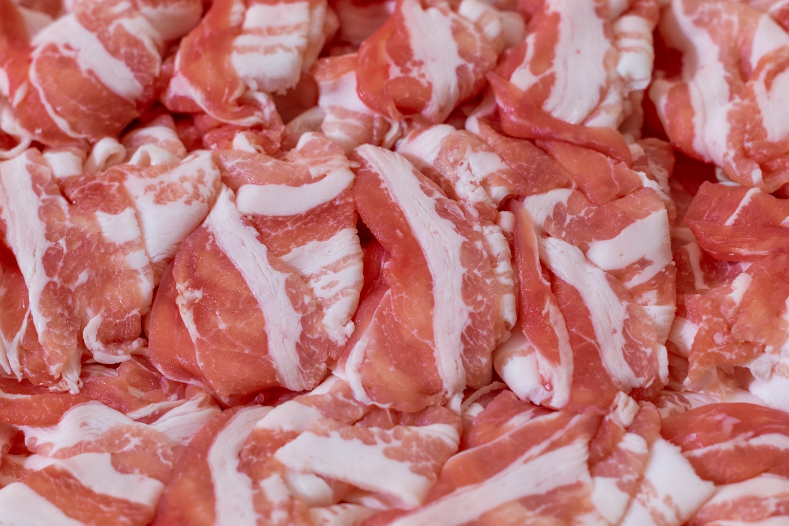 Dünne Scheiben Schweinefleisch in Schichten angeordnet