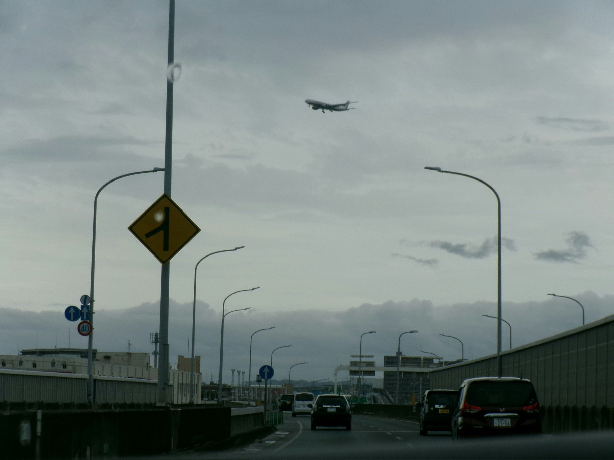 空港へ続く高架道路と飛行機のある空の風景