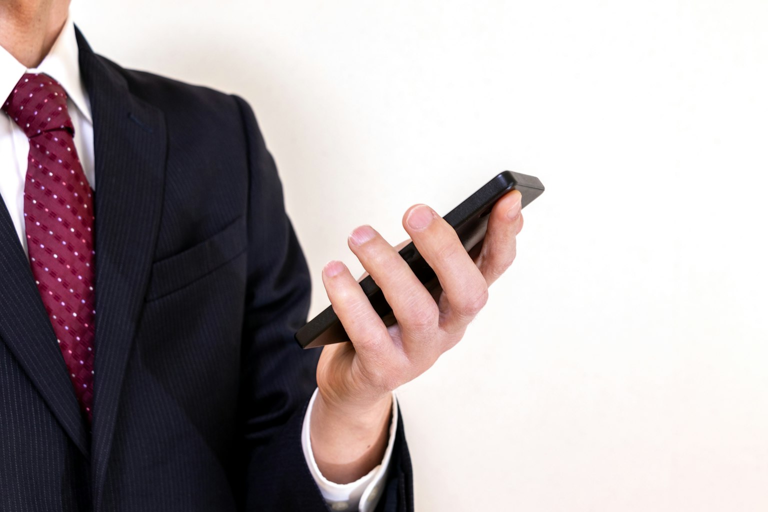 Ein Mann im Anzug hält ein Smartphone
