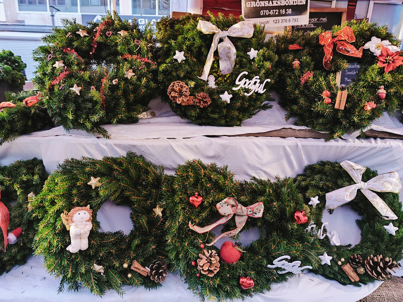 Una variedad de coronas de Navidad decoradas exhibidas