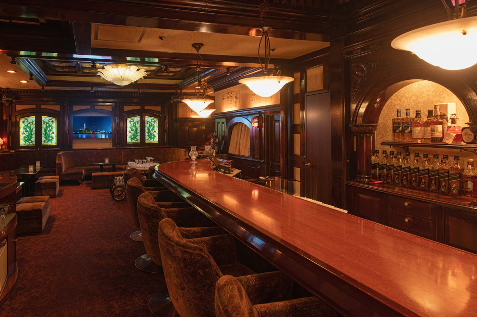 Interior de bar elegante con mostrador de madera y iluminación lujosa que ofrece un ambiente acogedor
