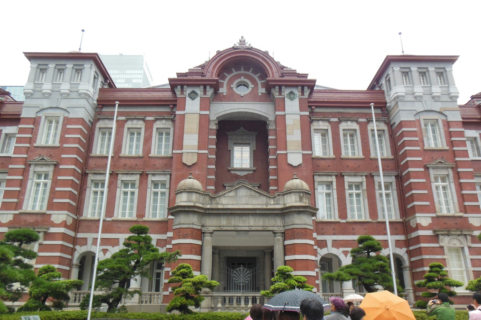 Facciata anteriore della stazione di Tokyo con architettura in mattoni rossi e vegetazione
