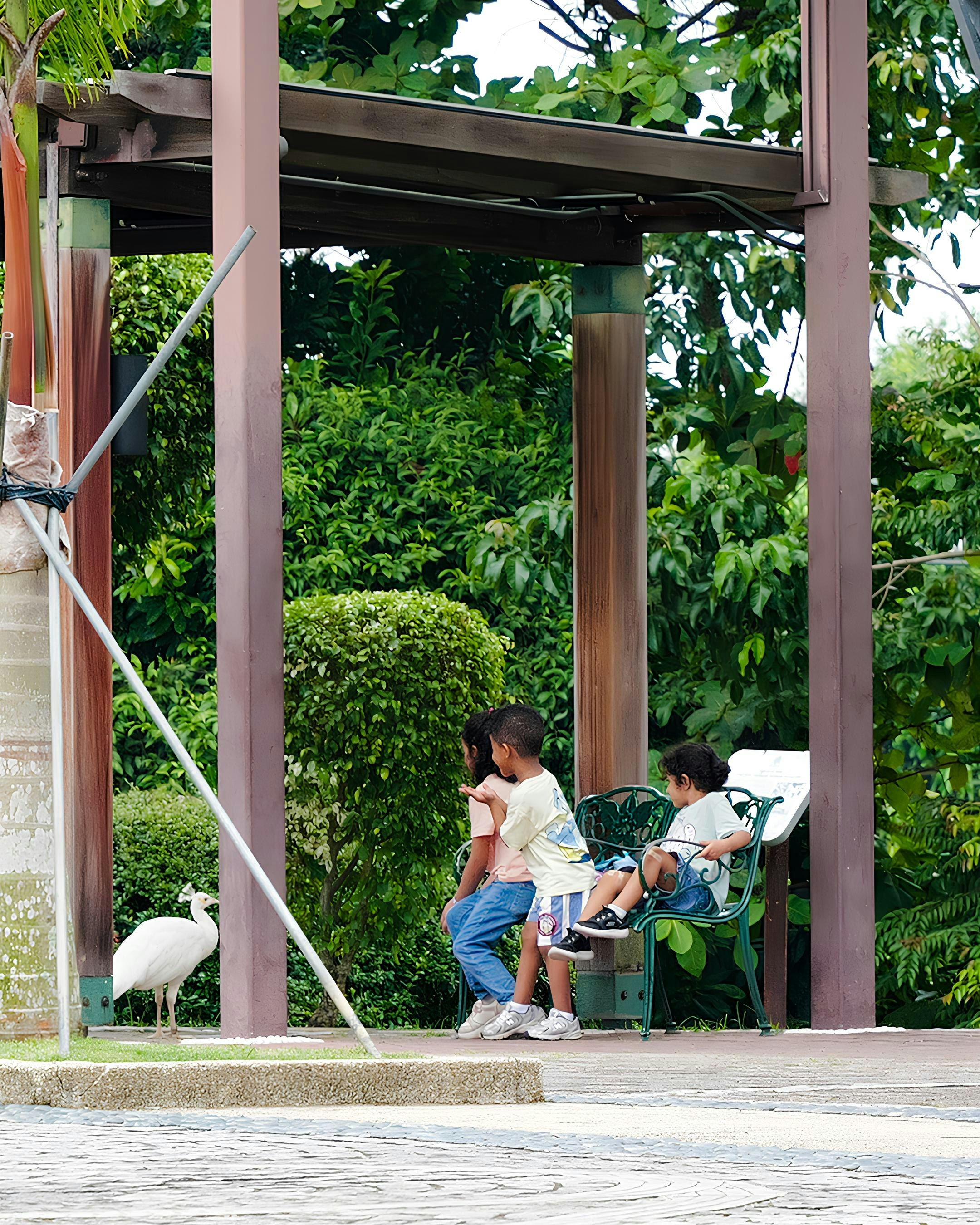 緑の庭を背景にベンチでくつろぐ親子のある屋外スペース