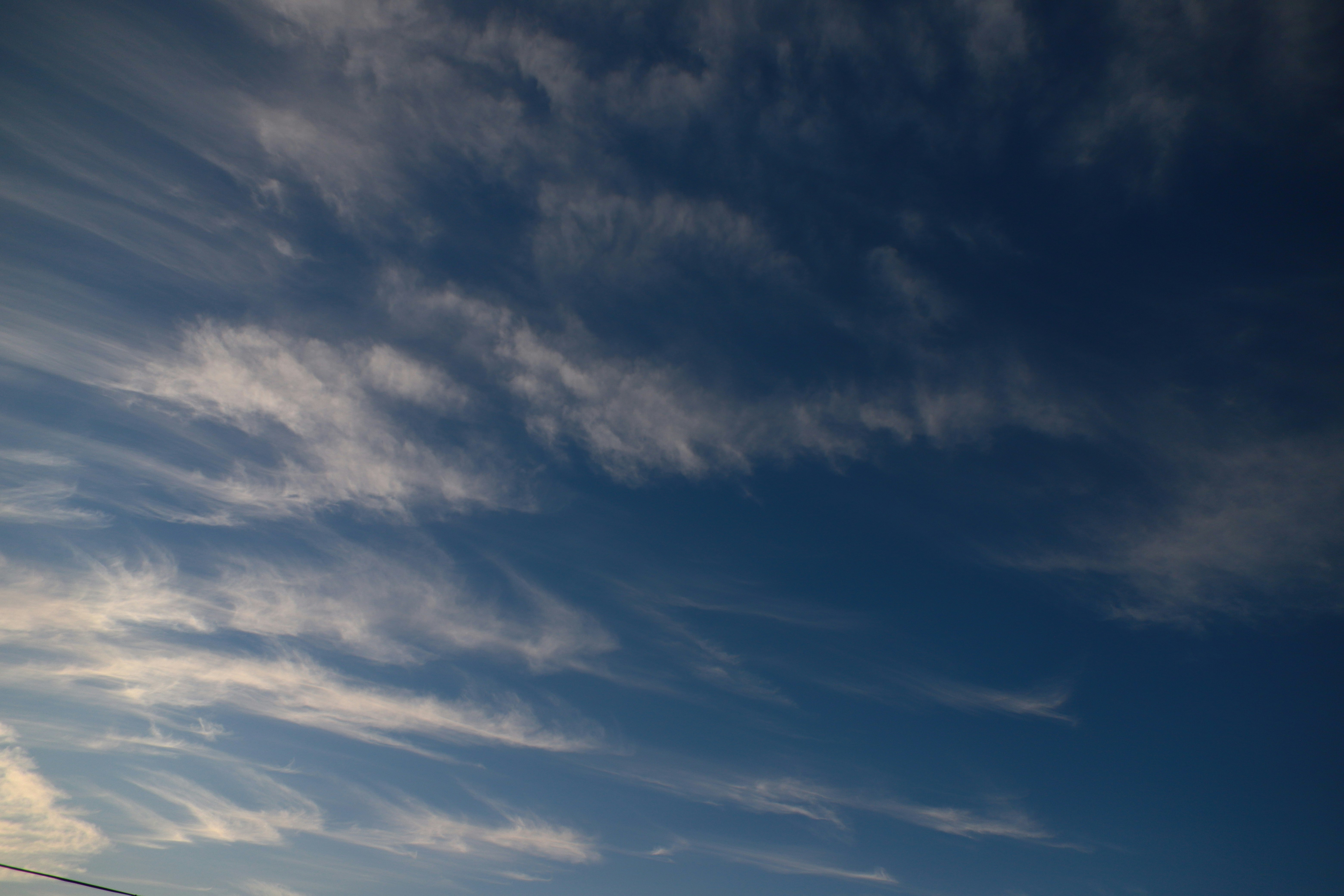 cloud streaks across a blue sky