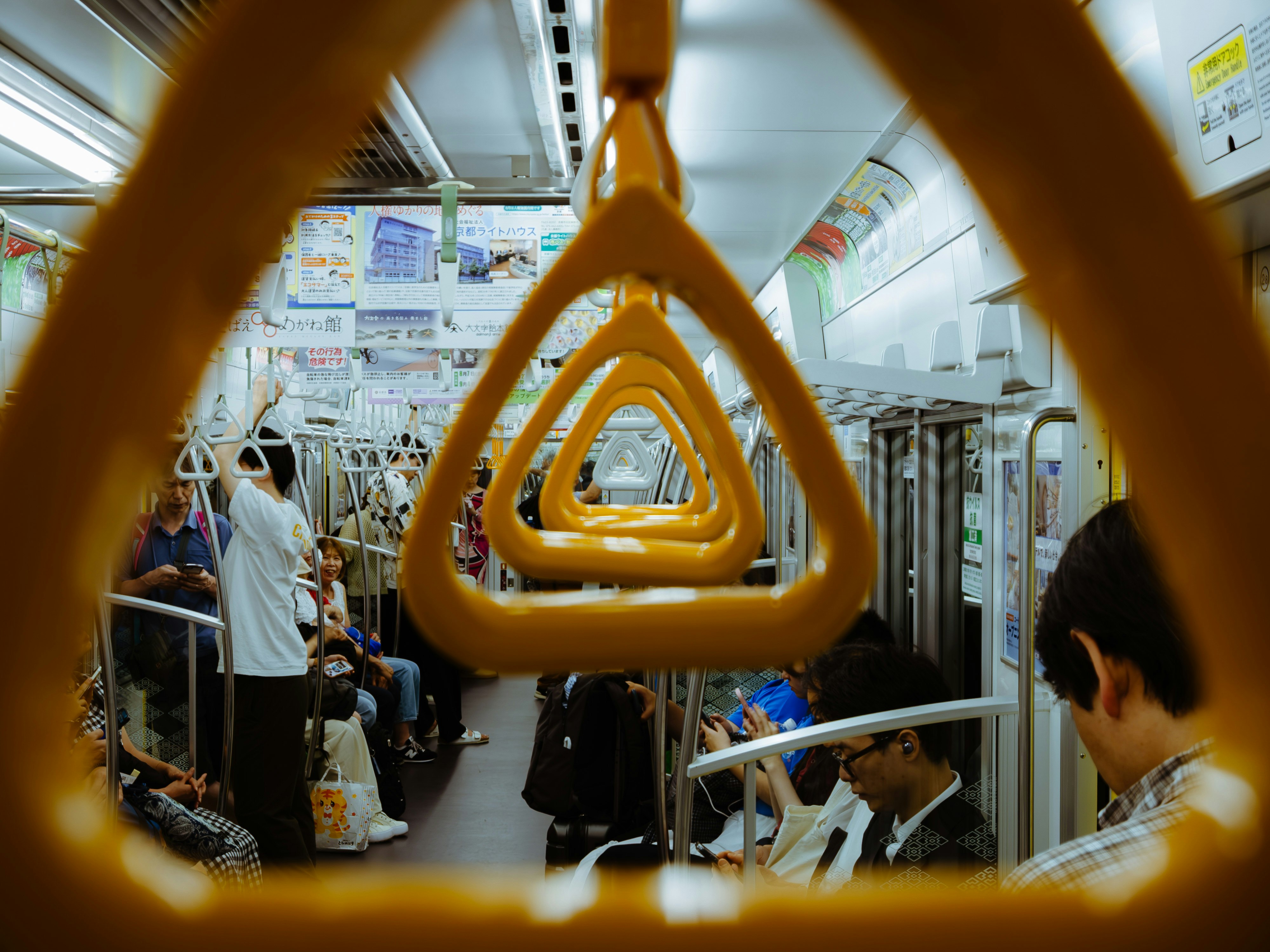 corridoio dell’interno del treno con maniglie gialle appese