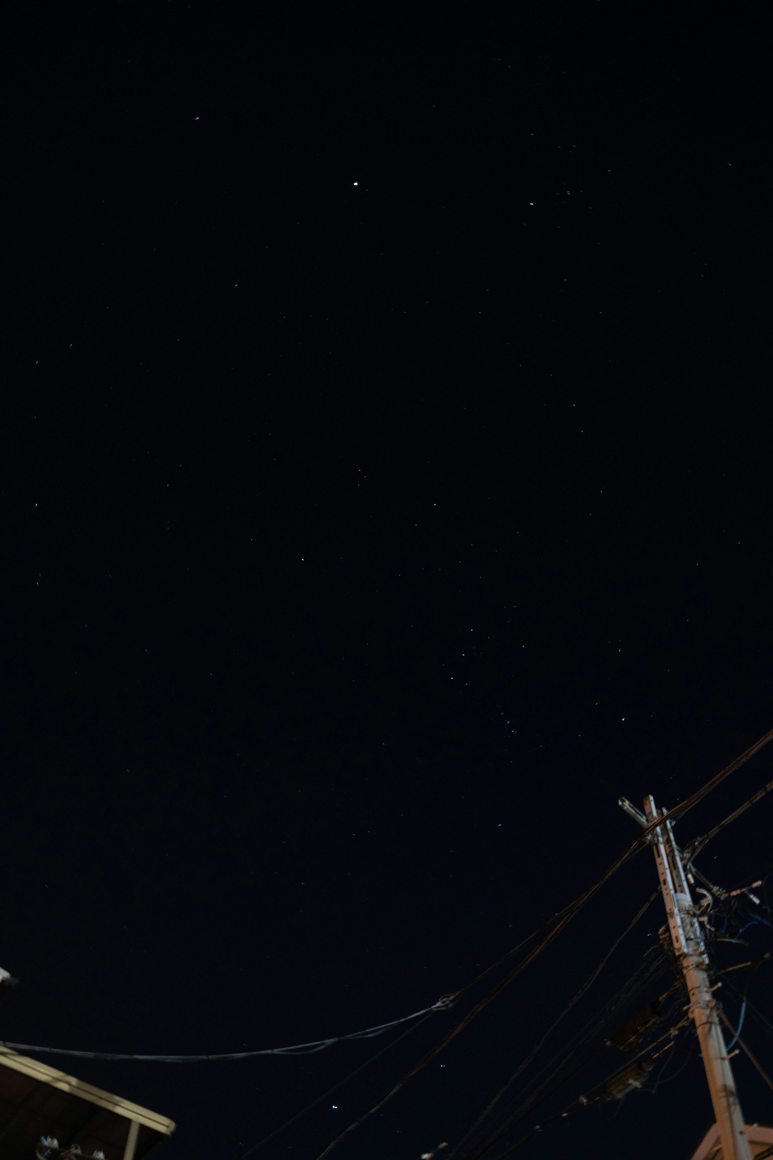 Langit malam dipenuhi bintang dan siluet tiang listrik