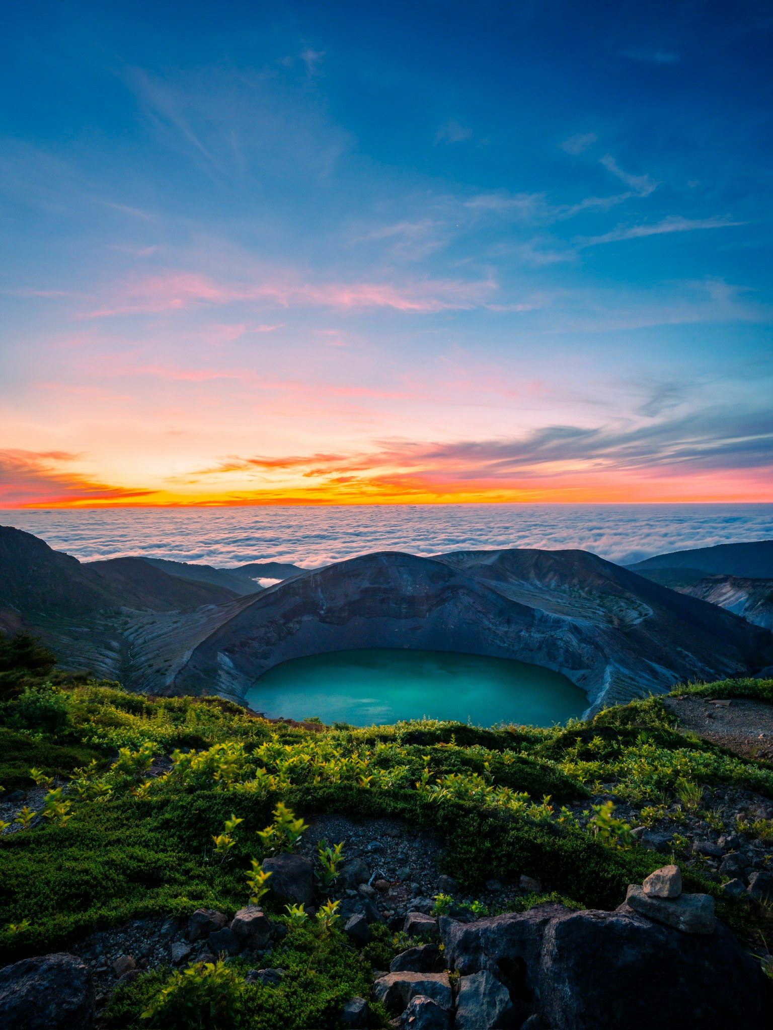 美しい夕焼けの中、クレーター湖が広がる風景 緑豊かな草原と青い空が印象的