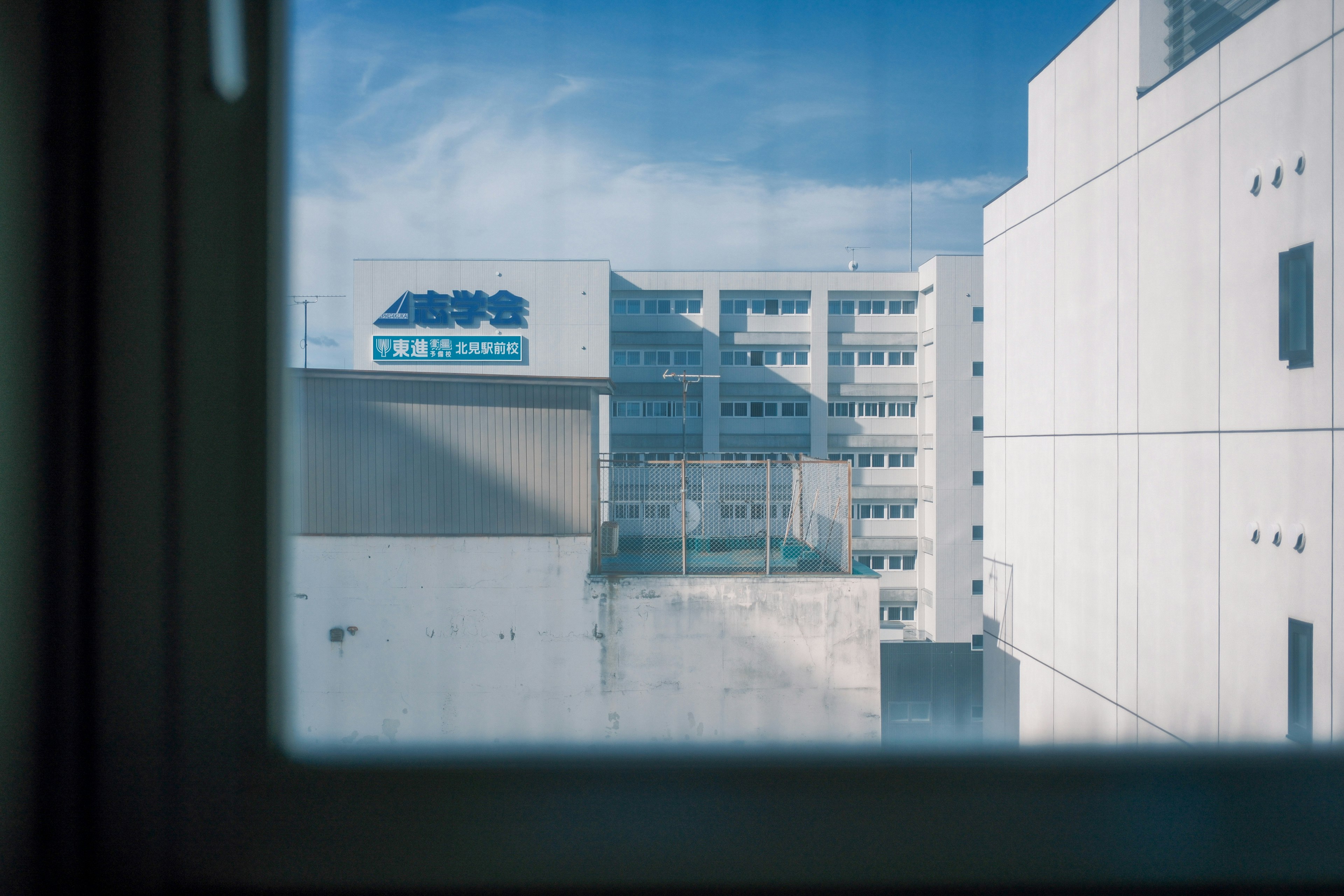 Vista del patio de un campus escolar a través de una ventana