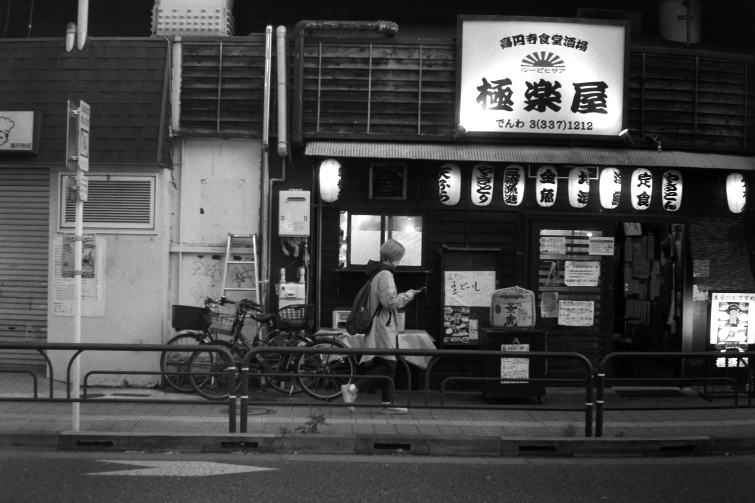 Eksterior kedai teh Jepang tradisional di malam hari dengan lentera dan papan nama