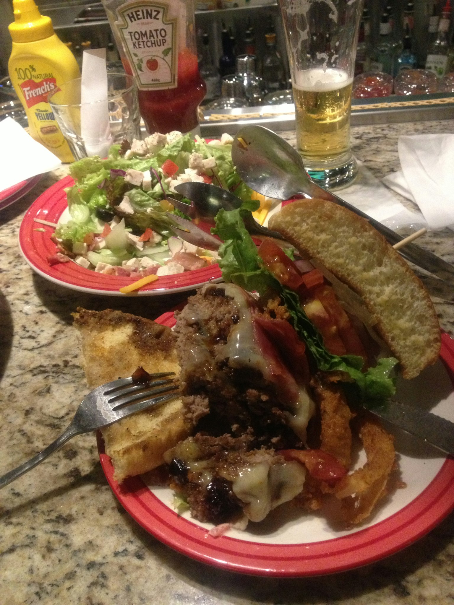 Un piatto di cibo con un panino, patatine e un'insalata in un bar