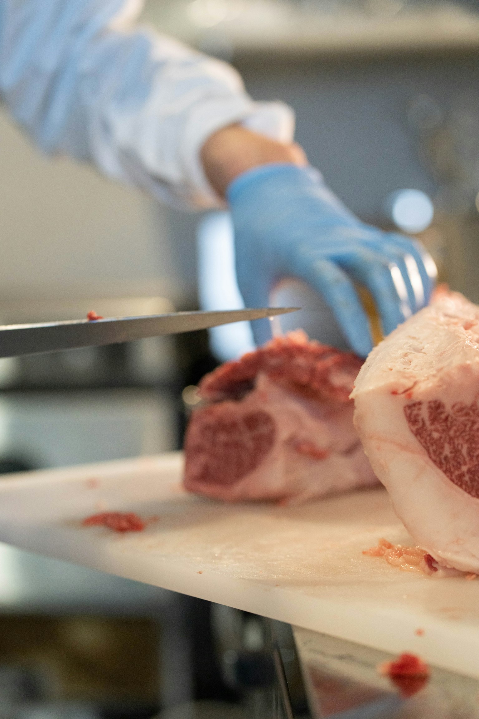 Eine Hand mit einem Messer, die ein Stück Fleisch schneidet