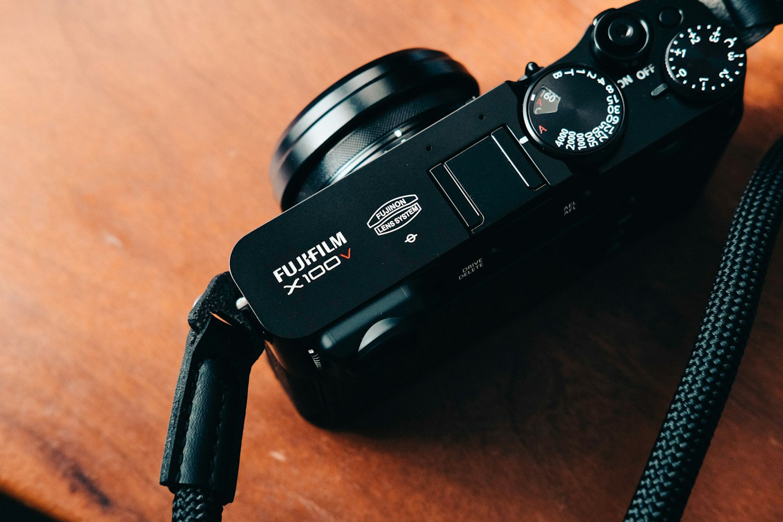 Máy ảnh Fujifilm X100 màu đen đặt trên bàn gỗ