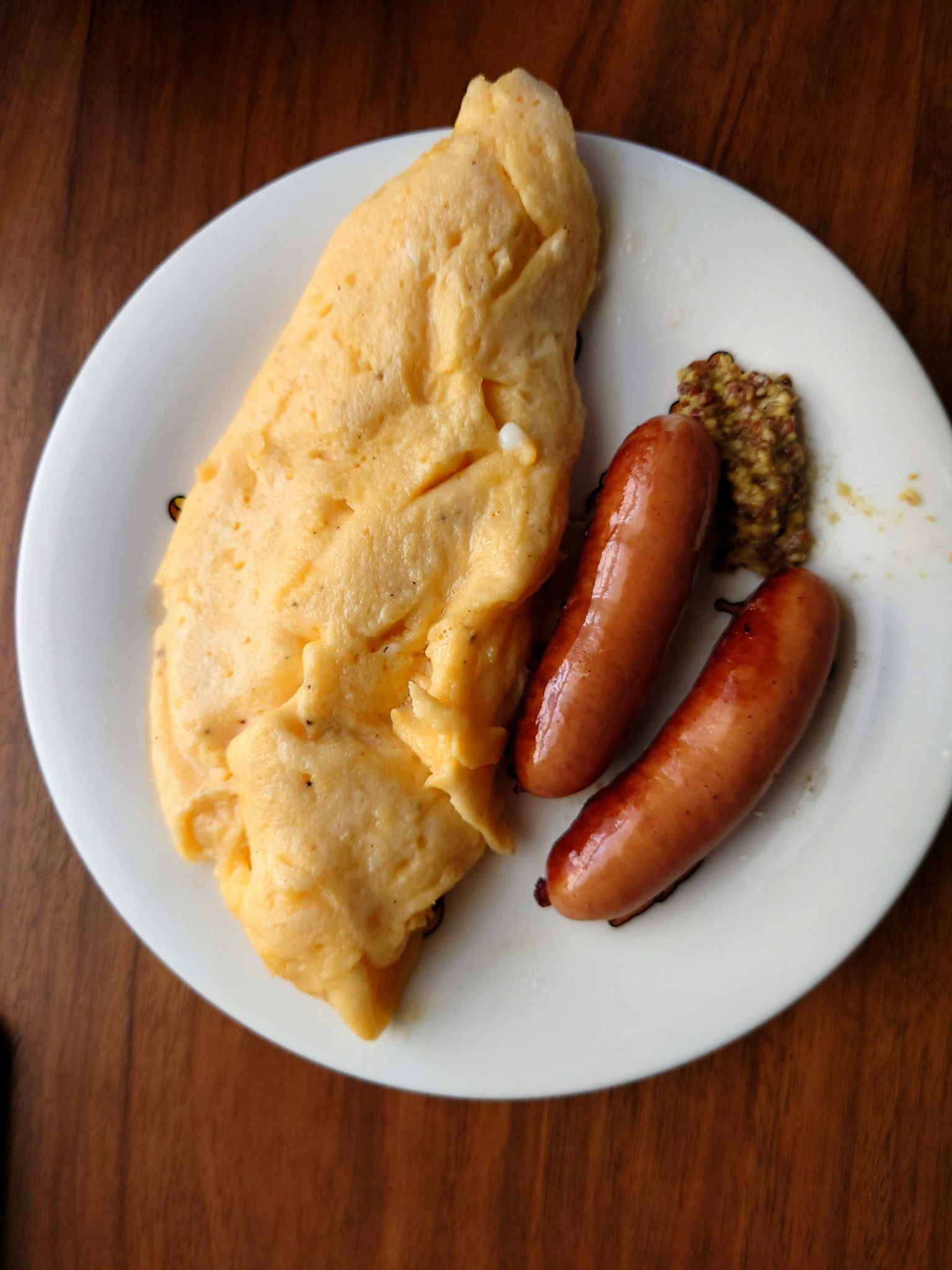 Plato con omelet esponjoso y salchichas