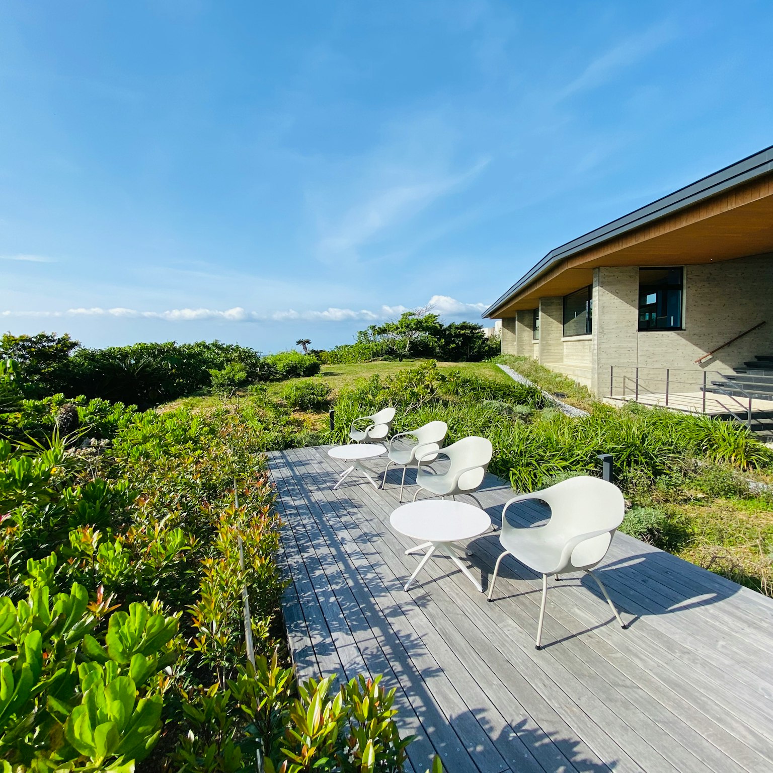 Moderne Haus Terrasse mit weißen Stühlen mit Blick auf üppiges Grün