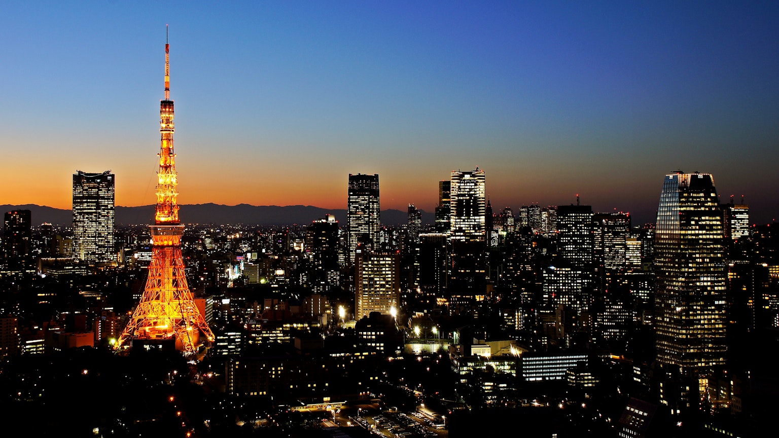 Tháp Tokyo phát sáng lúc chạng vạng với đường chân trời Tokyo