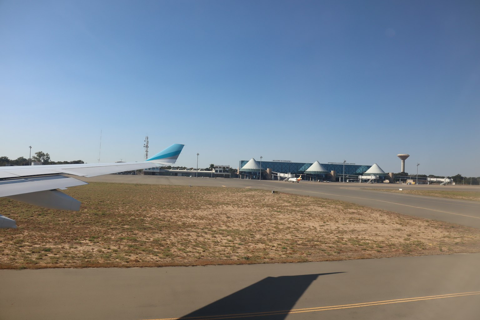 Vue d'une aile d'avion avec un aéroport en arrière-plan