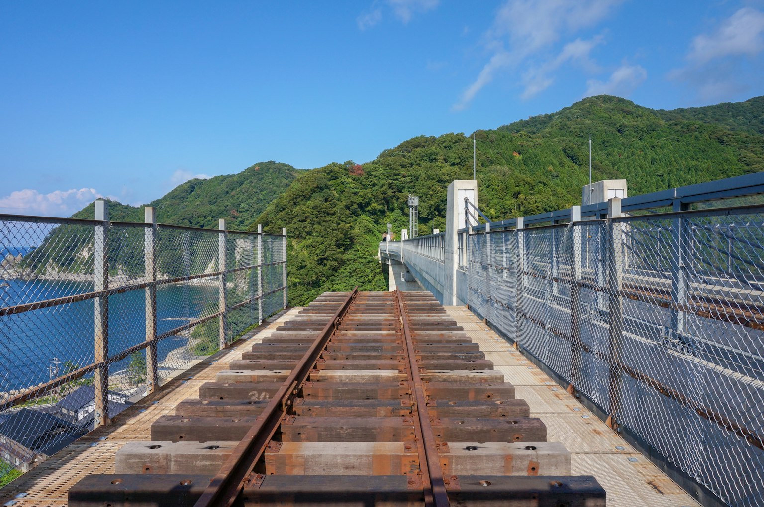 Rails de chemin de fer avec montagnes et océan en arrière-plan