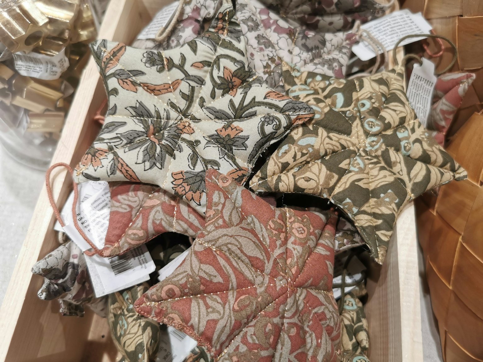 Décorations en tissu en forme d'étoile colorées disposées dans une boîte en bois