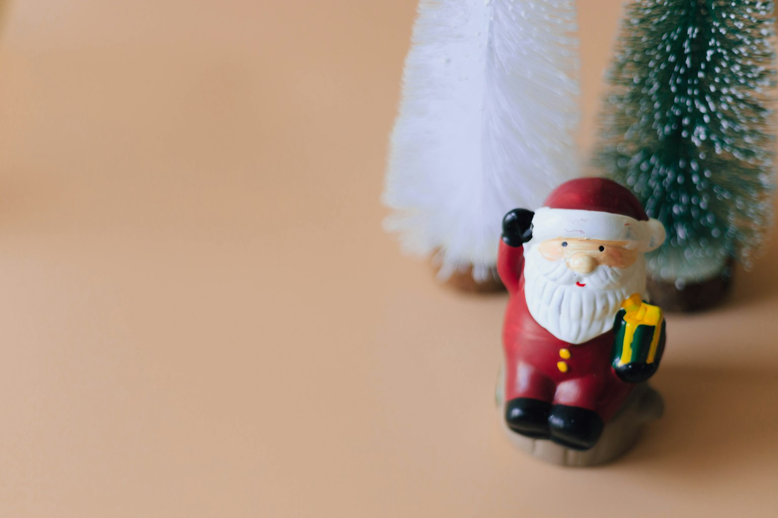 Eine kleine Santa Claus-Figur mit Weihnachtsbäumen