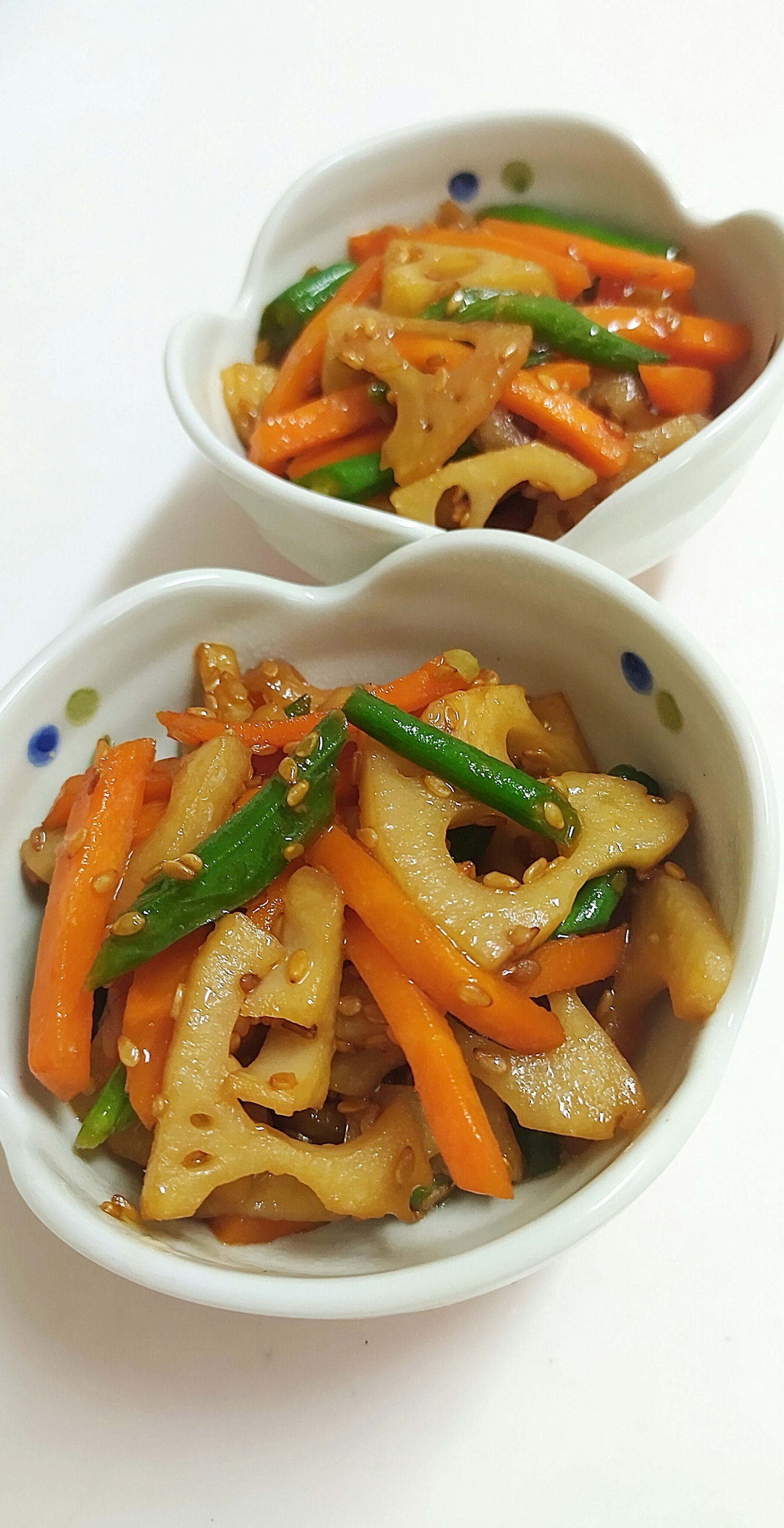 两个白色碗里盛着五彩缤纷的蔬菜炒菜