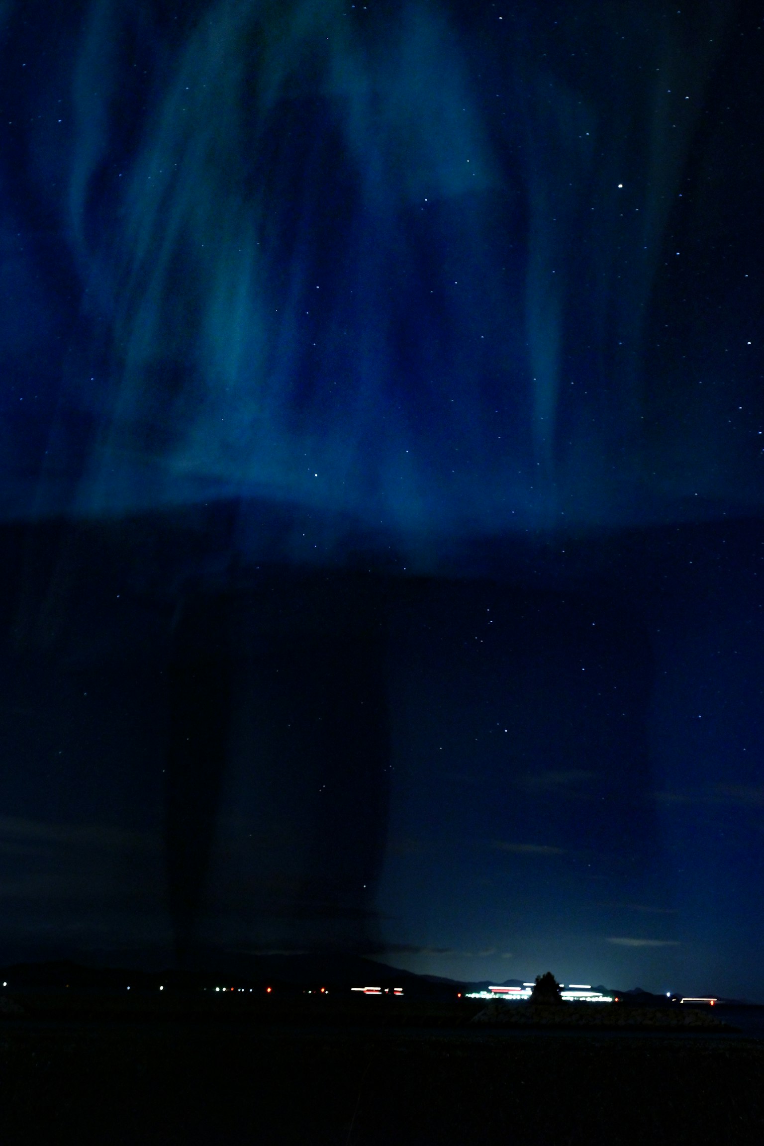 Aurore boréale avec des nuances de bleu illuminant le ciel nocturne étoilé