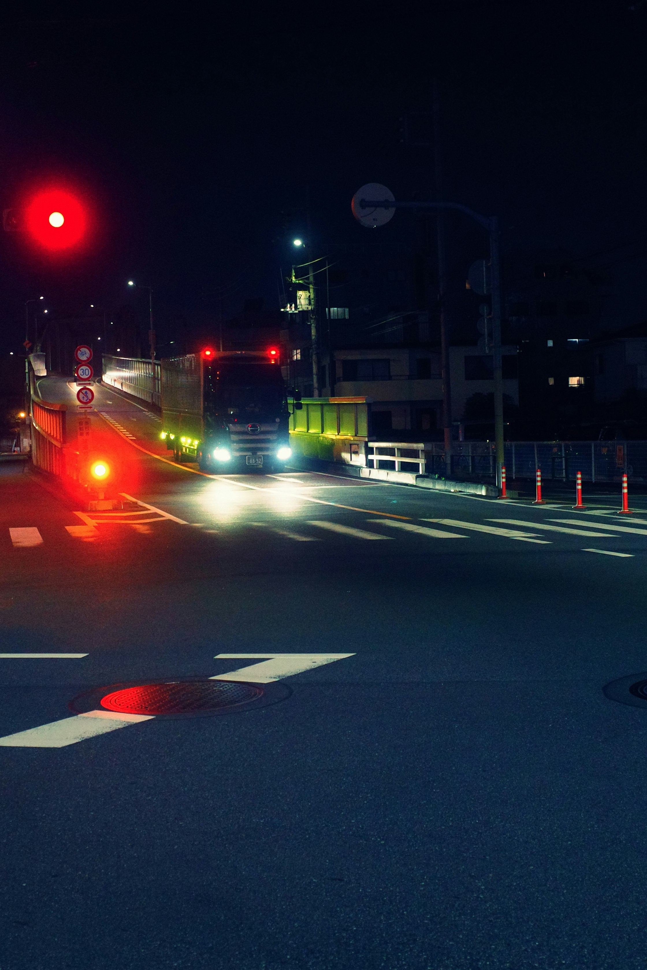 夜の交差点で点灯する信号と車線の白線