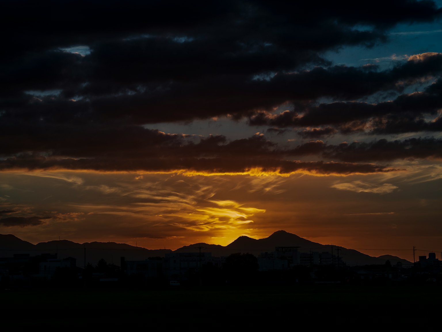 Atardecer sobre montañas con nubes dramáticas