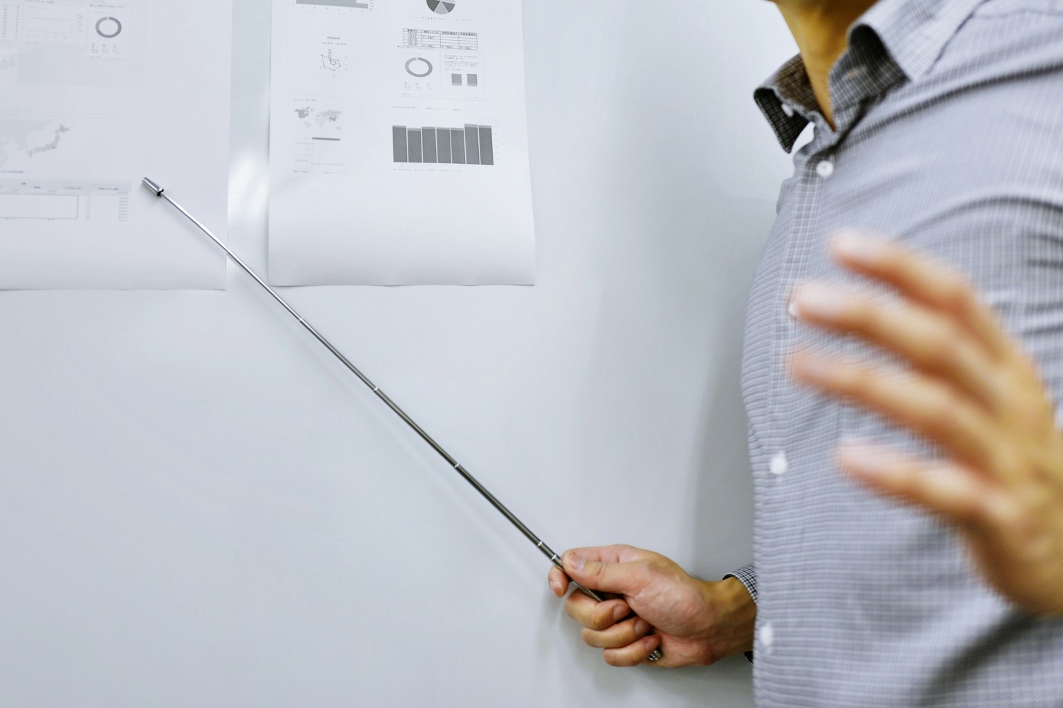 A man using a pointer to highlight documents during a presentation