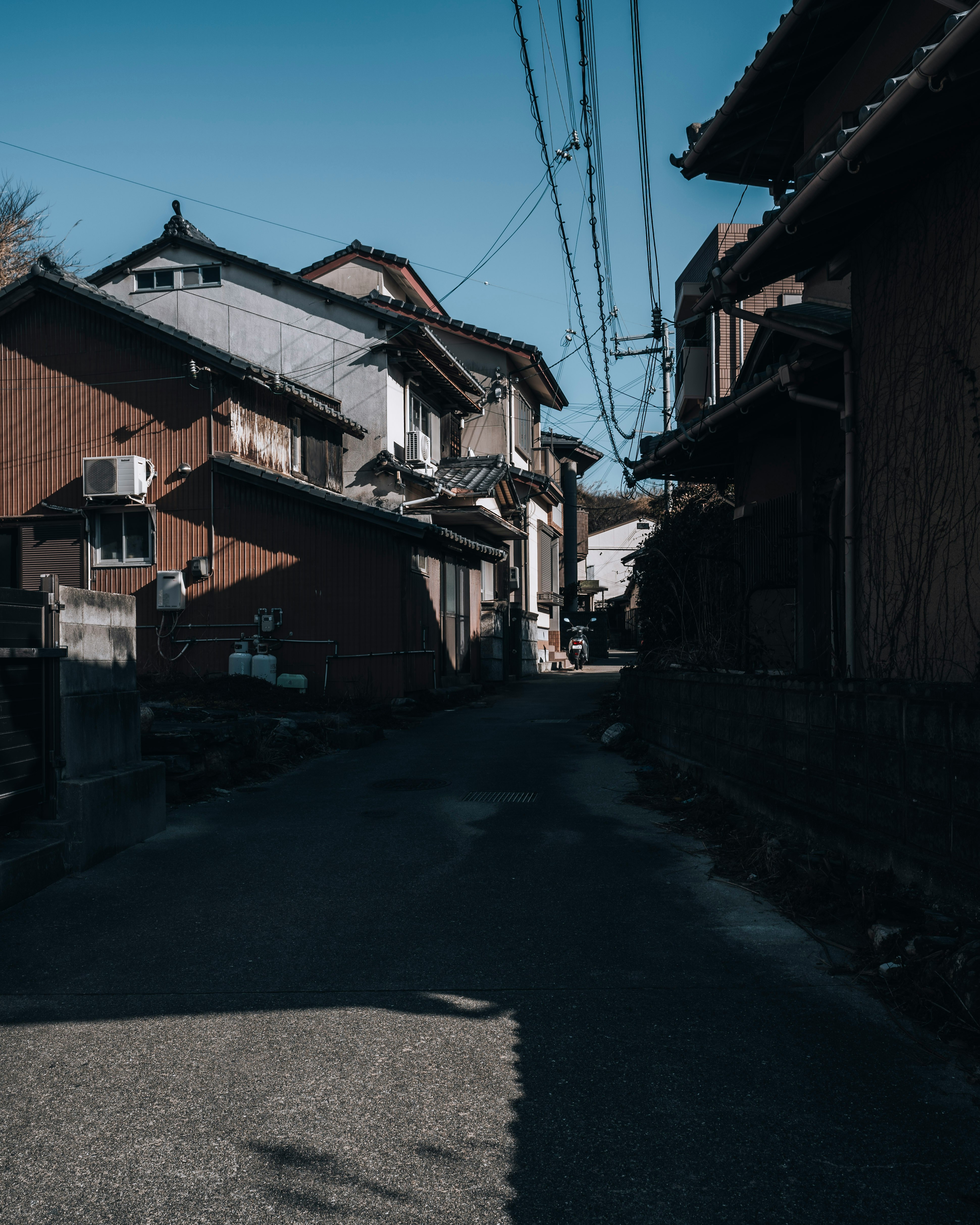 quiet residential alley with houses and overhead wires