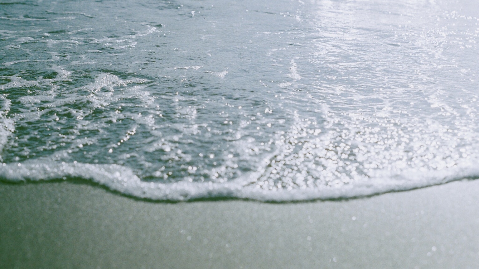 Waves gently washing onto a sandy beach