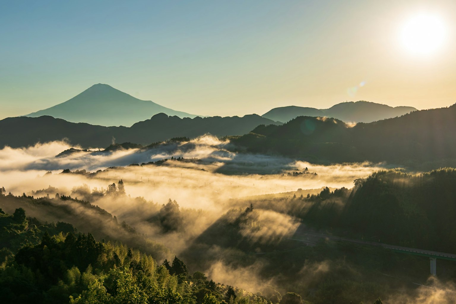 Vista panoramica di montagne e valli avvolte nella nebbia con l'alba che illumina il paesaggio